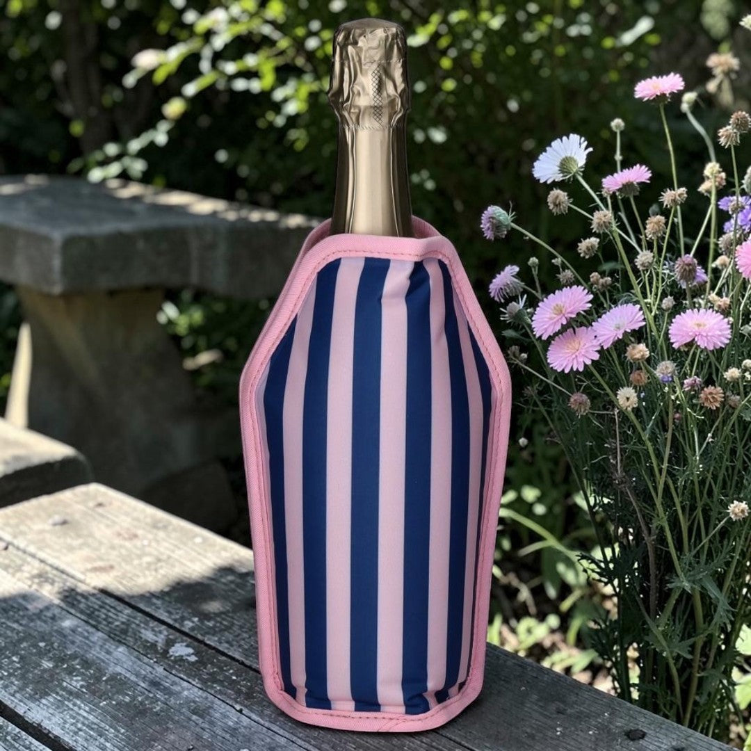 Nomafu Froid Kühlmanschette mit blau-rosa Streifenmuster um eine Weinflasche im Garten