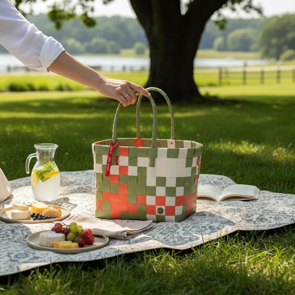 Nomafu ICE-BAG Klassik Shopper aus geflochtenem, mehrfarbigem Recycling-Kunststoff bei einem Picknick im Grünen