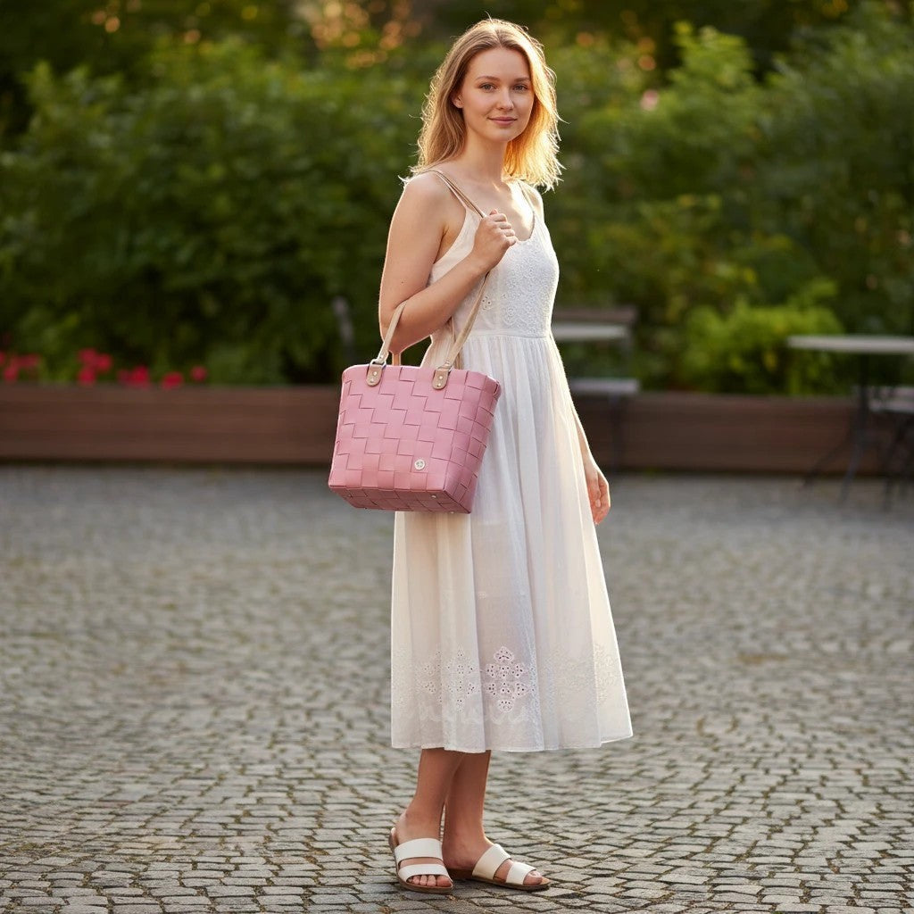Nomafu ICE-BAG RIVA Shopper in Altrosa aus geflochtenem Recycling-Kunststoff, getragen von einer Frau im Sommerkleid.
