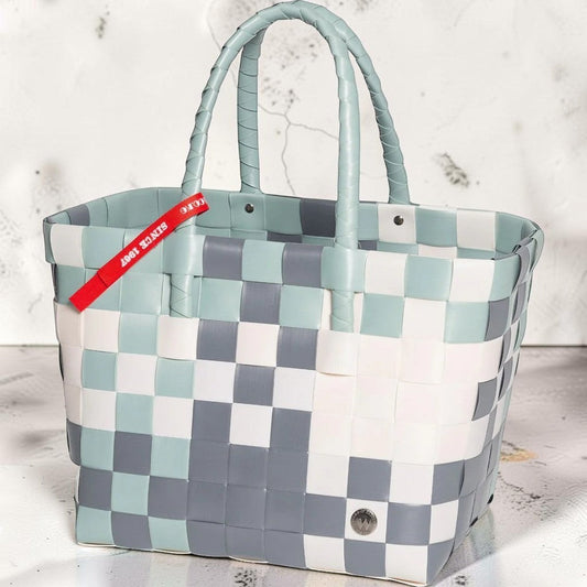 Nomafu ICE-BAG Klassik Shopper aus geflochtenem, mehrfarbigem Kunststoff in Blau, Grau und Weiß mit rotem Markenband.
