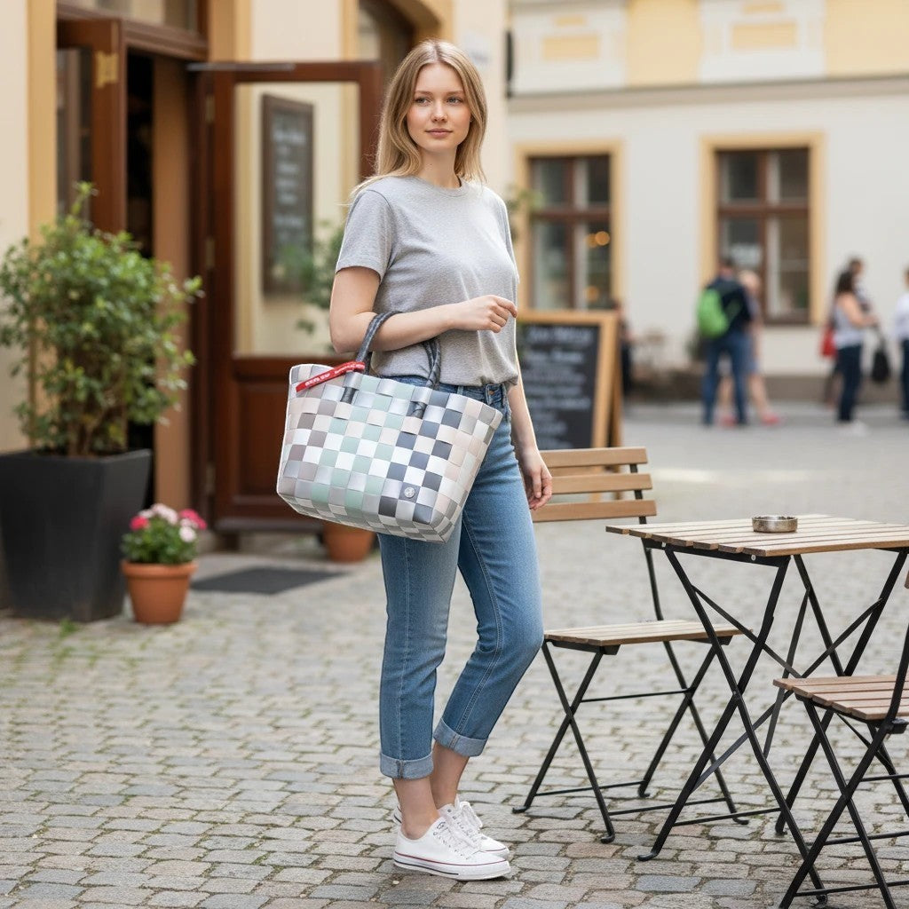 Nomafu ICE-BAG Klassik Shopper aus geflochtenem Recycling-Kunststoff in Mehrfarbig-Optik, getragen von einer Frau.