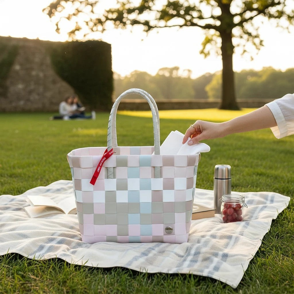 Nomafu ICE-BAG Klassik Shopper in Pastellfarben aus geflochtenem Recycling-Kunststoff auf einer Picknickdecke