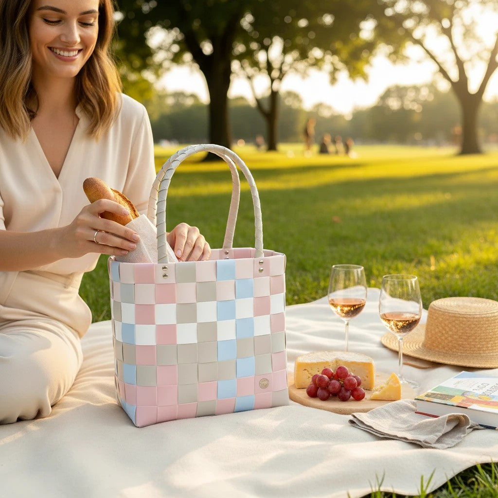Nomafu ICE-BAG Shopper in Pastellfarben aus geflochtenem Recycling-Kunststoff bei einem Picknick im Park