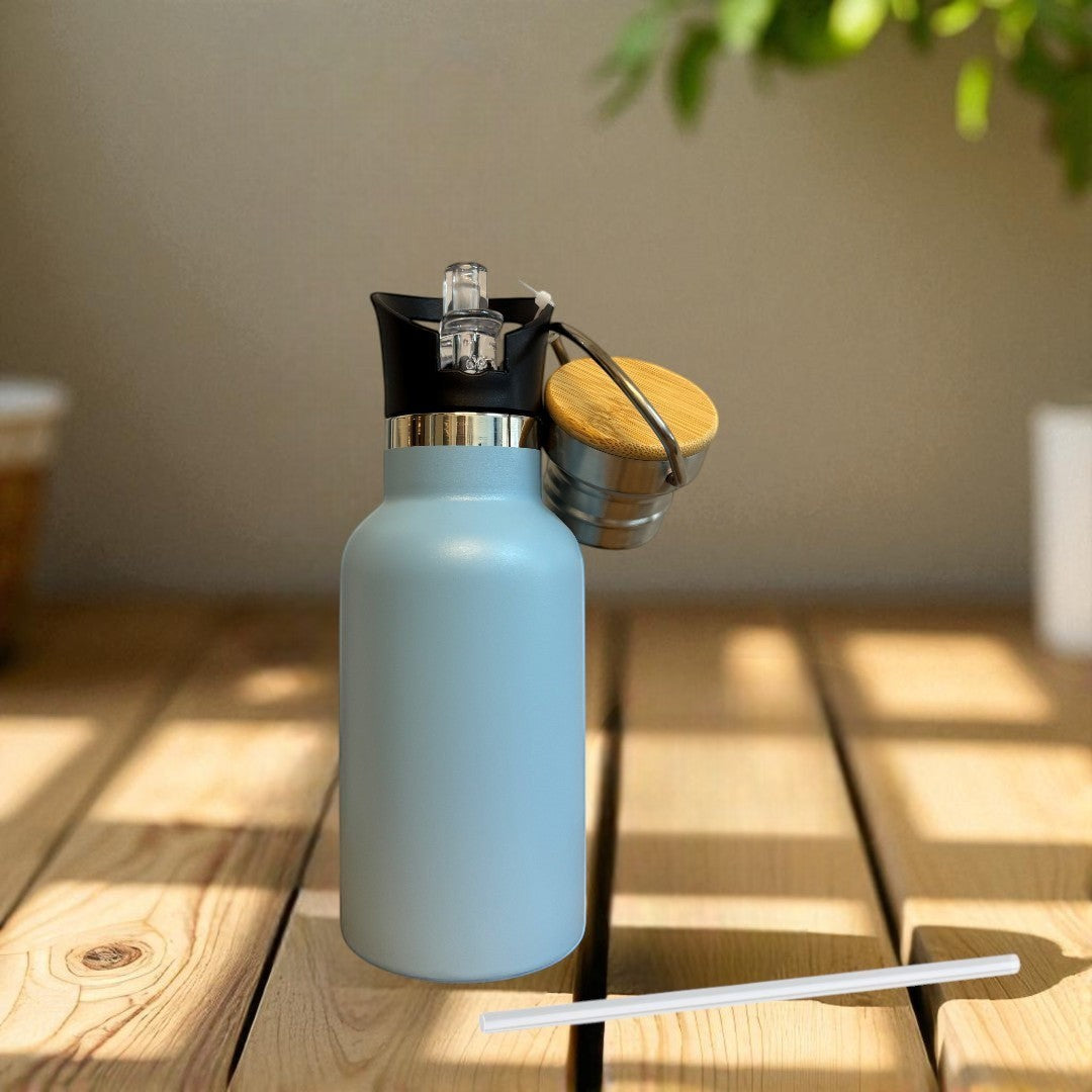 Nomafu 350ml light blue stainless steel insulated water bottle with sport lid and wooden cap on a wooden table.