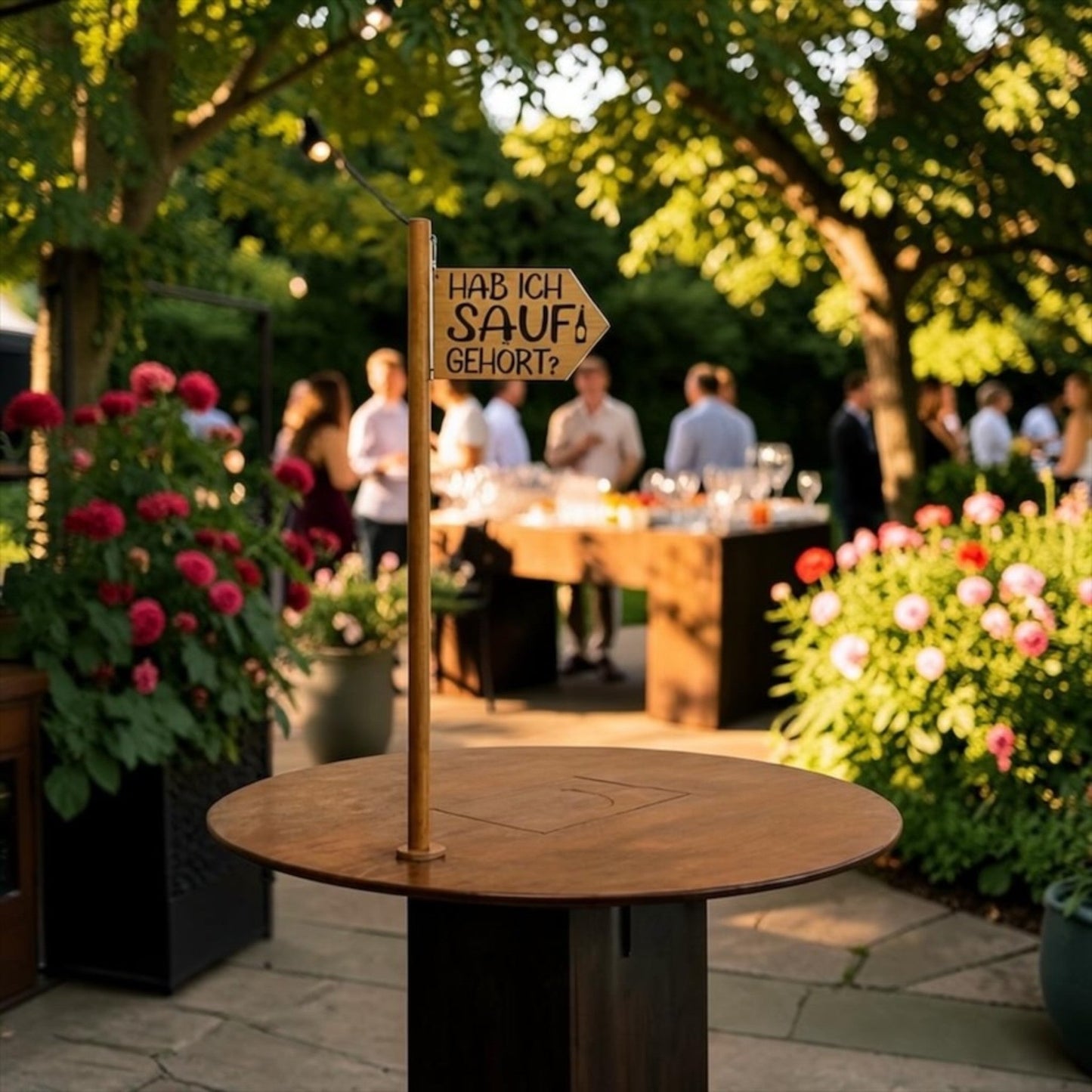 Nomafu Runde Kiste XXL standing table with a wooden sign in a garden setting during a party.