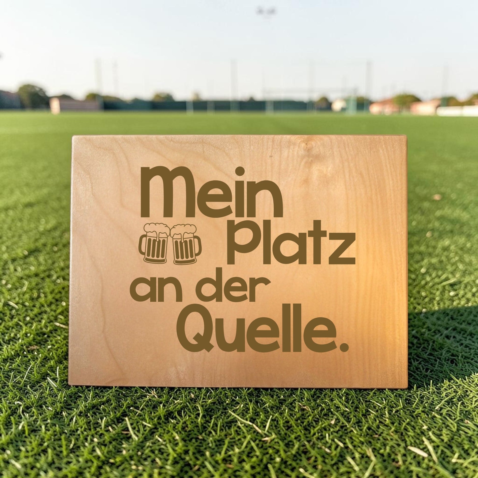 Nomafu wooden crate seat topper with custom laser engraving on a green sports field background.